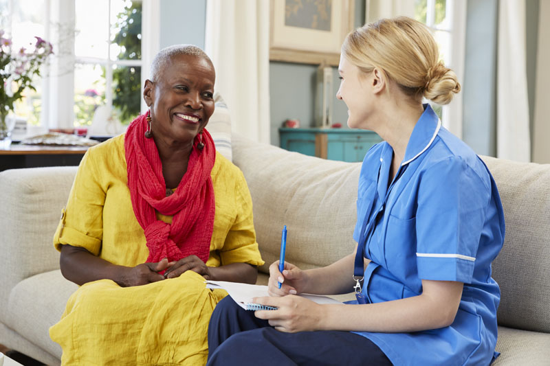 female home health nurse visits senior woman at home