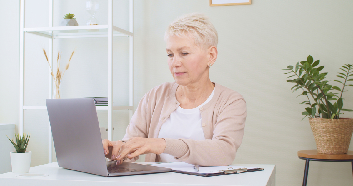 senior woman using laptop to find low income senior apartment