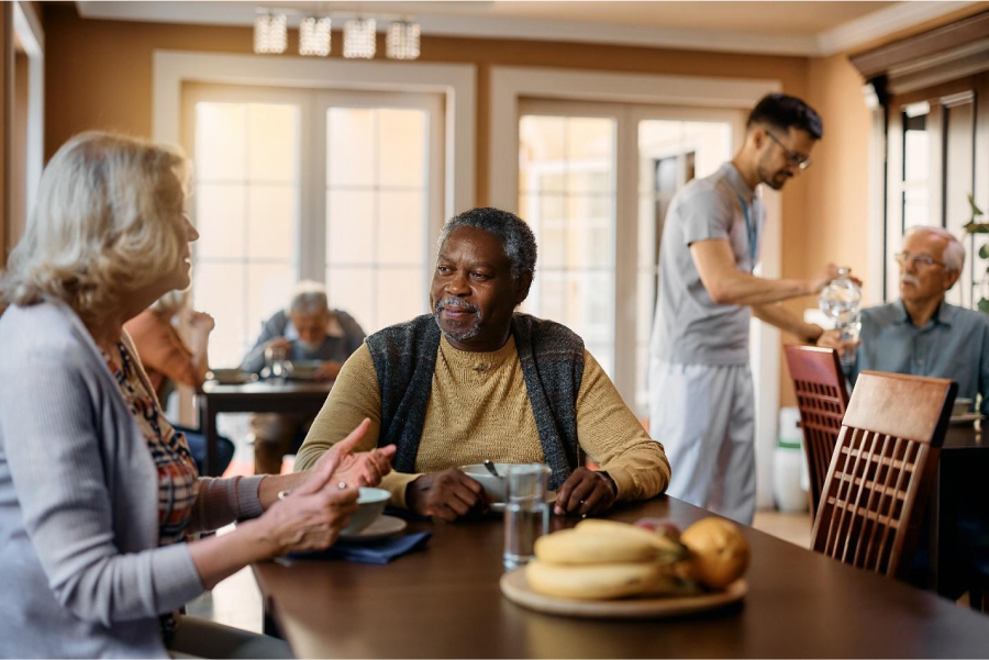 senior people talking while eating lunch in living room