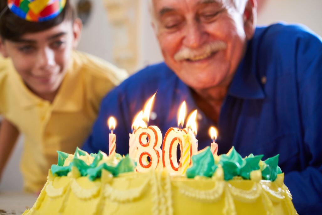 boy and senior man blowing candles on cake
