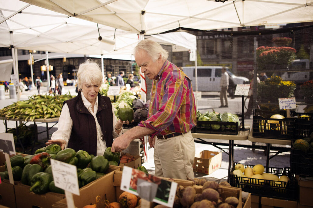 senior couple buying vegetables at street market 1