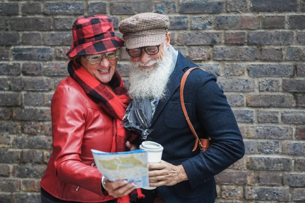 senior couple looking at travel map while exploring