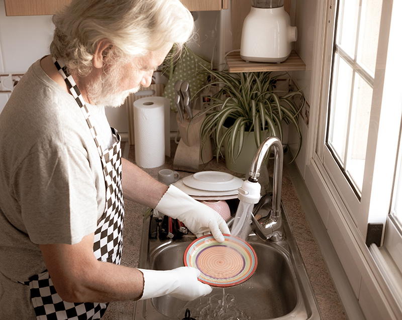 senior man washing dishes