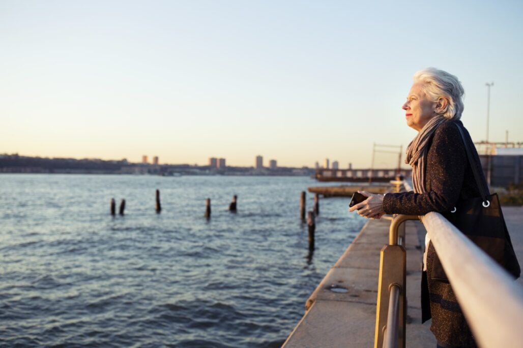 side view of senior woman leaning on railing