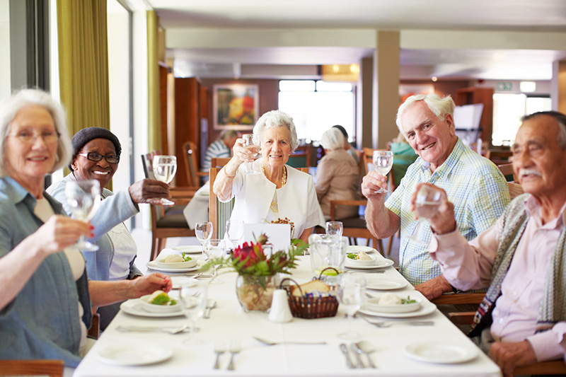 a group people raising glasses in a toast